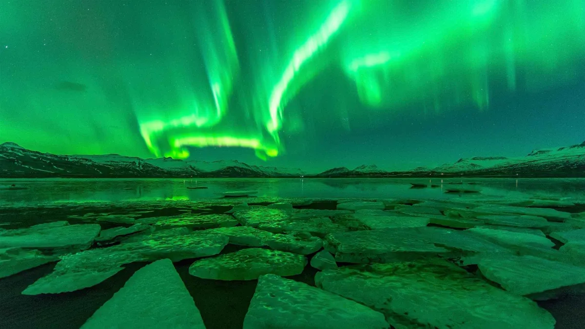 Aurora over a glacier lagoon on a 5-day northern lights hunt that overnights near Vík, Iceland