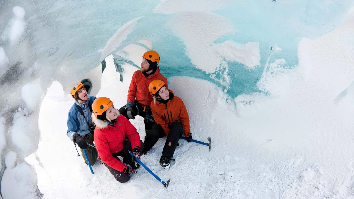 Hikers roped up on the blue ice of Sólheimajökull glacier near Vík, Iceland, a daytime trip between northern lights nights